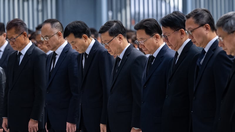 Hong Kong Chief Executive John lee, center and other officers observe a moment of silence for...