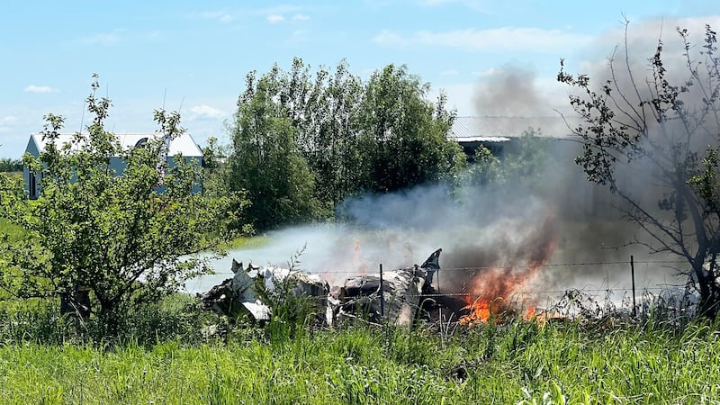 The wreckage of a plane crash burns in a field in Butler, Mo, Sunday, June 14, 2026. (Mid...